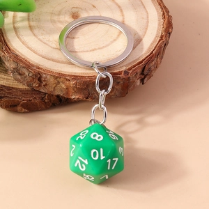 Close-up of bright green D20 dice keychain with white numbers on a wood base
