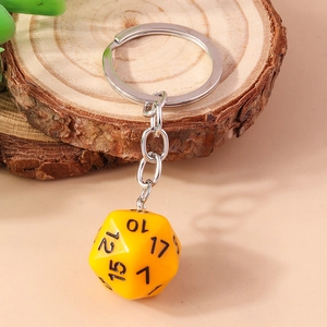 Close-up of a yellow 20-sided D20 dice keychain on a rustic wooden decorative block