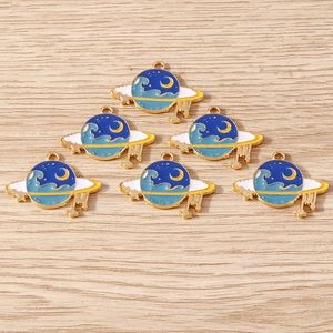 Blue and gold enamel space charms set with crescent moon, stars and planet designs