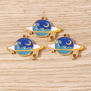 Detail showing blue enamel star and moon alloy charms with golden key-shaped base