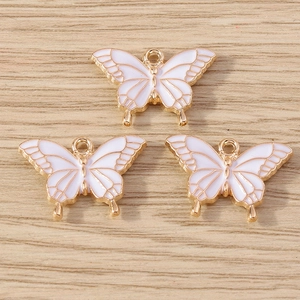 Vue détaillée de trois breloques papillon blanc et doré pour la création de bijoux