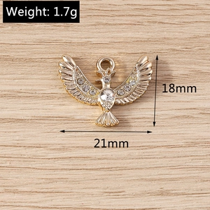 Detailed view of a gold eagle pendant with clear rhinestones measuring 18mm by 21mm