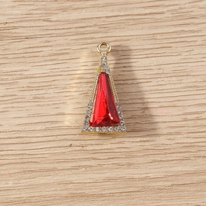 Macro detail of geometric triangle pendant with red crystal and sparkling white rhinestones
