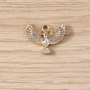 Macro view of gold eagle pendant with sparkling crystals and a closed loop for DIY jewelry
