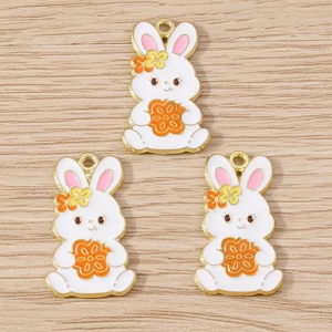 Detailed close-up of three white enamel rabbit pendants on a natural wood background