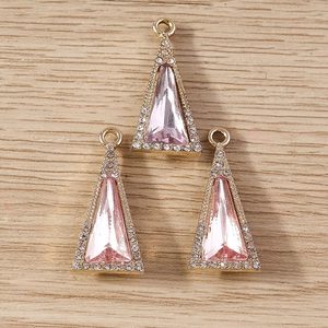 Macro detail of three pink triangle crystal pendants with gold edges and zircon inlay