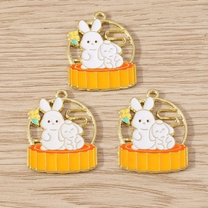 Detail of Chinese style enamel rabbit and mooncake charms with golden finish and orange oil
