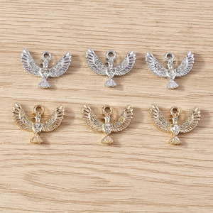 Macro view of gold and silver plated bird pendants with white rhinestones for DIY jewelry making