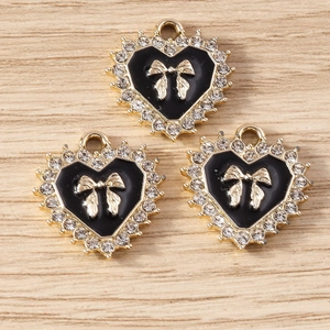 Detail van hartvormige legering bedeltjes met zwart emaille en glanzende strass