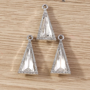 Macro shot of silver triangle crystal pendants with inset rhinestones on wood