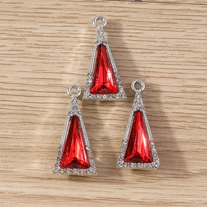 Three deep red crystal triangle pendants with silver rhinestones on a wooden background