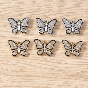 Détail des pendentifs papillon en argent et or avec des strass en cristal brillants