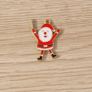 Macro detail of Santa Claus enamel pendants with metal rings on a wood background