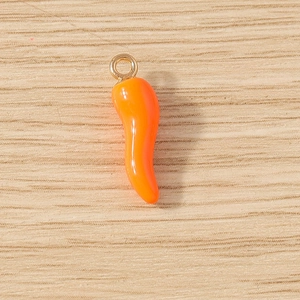Detailed view of glossy orange chili pepper pendant with golden ring for DIY jewelry making