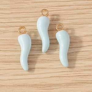 Three light blue enamel cornicello chili pendants with gold rings on wooden background