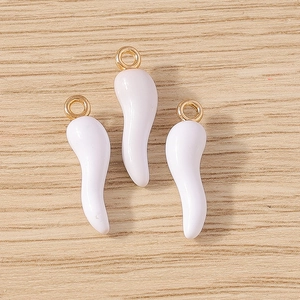 Close-up of three cream-colored horn-shaped resin pendants with gold metal hanging loops