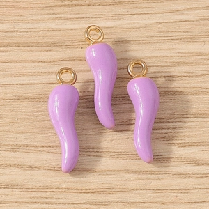 Detailed view of three purple chili pendants with gold rings for DIY jewelry making