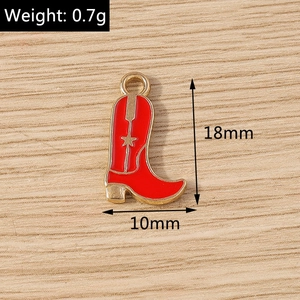 Vue macro d'un pendentif botte de cow-boy en émail rouge 18x10mm avec étoile dorée