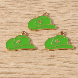 Detailed view of three neon green enamel cowboy hat pendants with gold stars on wood background