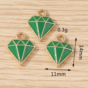 Macro-opname van drie groene emaille hangers in diamantvorm met goudkleurige rand