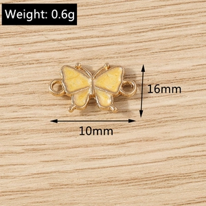 Detailed view of 16mm yellow enamel butterfly charm with gold metal loops for DIY jewelry