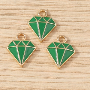 Macrodetail van ruitvormige groene emaille bedeltjes met gepolijste goudkleurige randen