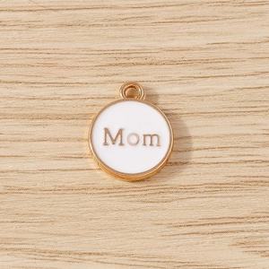 Detailed macro of golden metal Mom charm with white enamel for DIY bracelet making