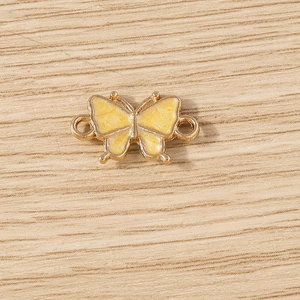 Detailed macro of yellow enamel butterfly jewelry connectors for DIY necklaces