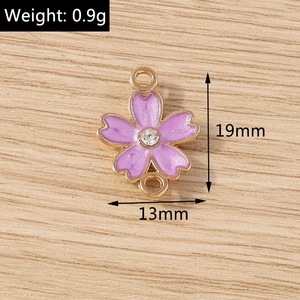 Detailed macro view of purple enamel flower connector with rhinestones for DIY jewelry
