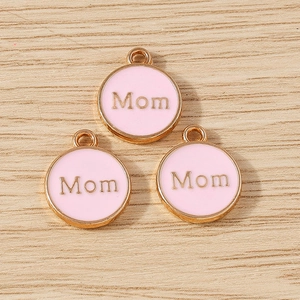 Close-up of pink enamel Mom charms with gold-plated edges for DIY jewelry making