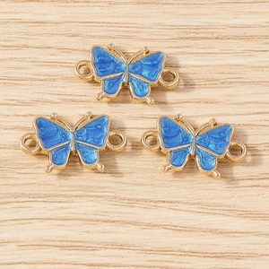 Detailed macro of golden metal butterfly charms with blue enamel for DIY jewelry making