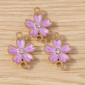 Detailed macro of cherry blossom enamel pendants with double loops and clear rhinestones