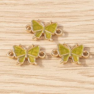 Detail of green enamel butterfly connectors in gold metal for DIY jewelry making