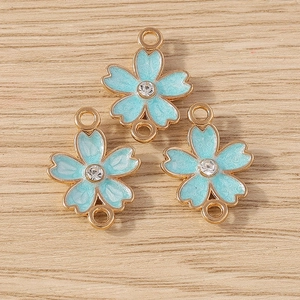 Detail of light blue enamel flower charms with gold plating and cubic zirconia for DIY jewelry