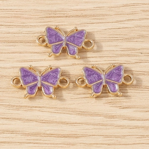 Detailed macro view of purple enamel butterfly charms with gold alloy double rings