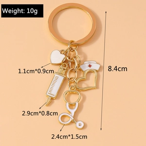 Détail d'un porte-clés médical avec cœur, seringue et stéthoscope au fini doré brillant