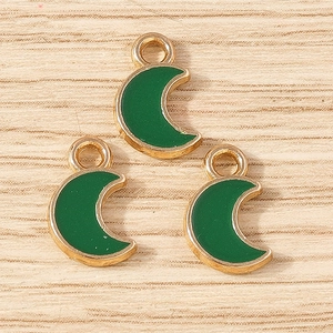 Detailed macro view of dark green enamel crescent moon charms with gold alloy plating