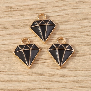 Detail van drie zwarte ruitvormige legering hangers met gouden rand en emaille afwerking
