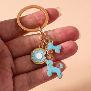Golden keychain with cute light blue poodle dog, bone and bitten donut pendants