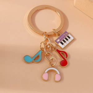 Porte-clés musical doré avec clavier coloré, notes et pendentifs de casque audio