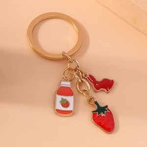 Porte-clés doré avec breloques en émail d'un lapin, d'une fraise et d'un biberon