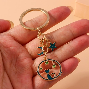 Golden keychain featuring blue cat silhouette with moon and star enamel pendants