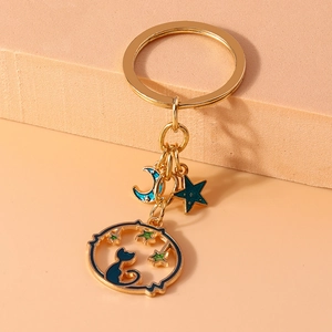 Golden cat silhouette keychain with moon and star pendants in blue and green enamel finish