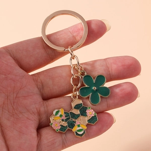 Portachiavi floreale con fiore verde e ciondoli a nido d'ape con piccole api e fiori di ciliegio