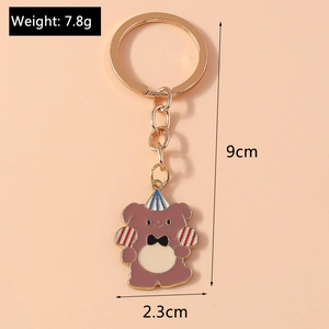 Cartoon brown bear keychain with dimensions 9cm length and 2.3cm width on pink background