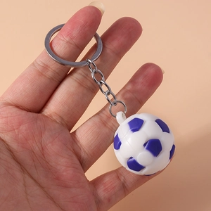 Miniature blue and white soccer ball keychain with silver metal ring held in hand