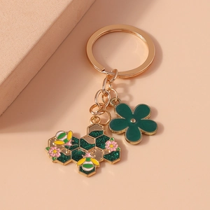 Portachiavi in stile pastorale con fiore verde e ciondolo ad ape su sfondo color pesca