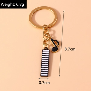 Detailed view of music themed keychain with piano keys and note pendant including measurements