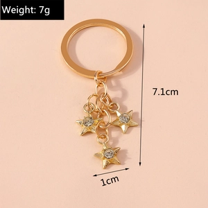 Detail view of a gold star keychain with rhinestones showing dimensions 7.1cm and 7g weight
