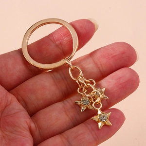 Sparkling gold star keychain with rhinestones and circular ring held in hand